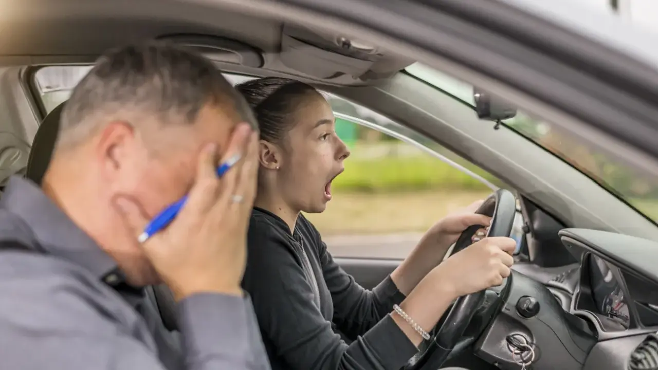 Instructor desesperado mientras una joven conductora, con cara de sorpresa, intenta sacarse el carnet de coche.