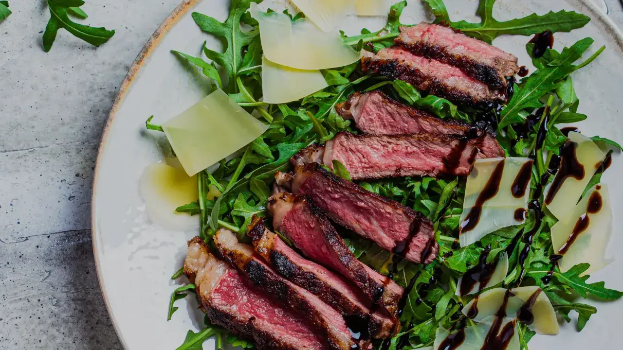 En saftig tagliata på en bädd av rucola med parmesanflisor och balsamico. Ett perfekt tagliata recept för en snabb och lyxig middag.