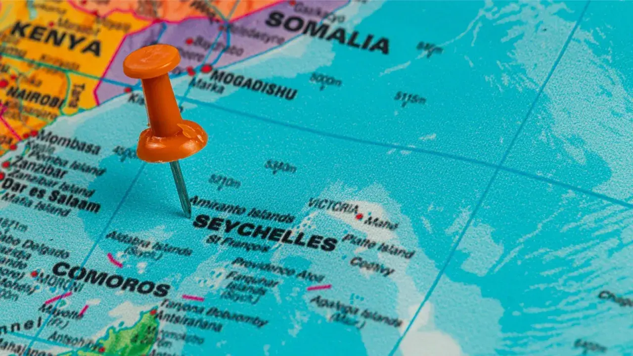 Pomarańczowa pinezka wskazuje na Seszele na mapie, pokazując gdzie leżą te wyspy na Oceanie Indyjskim, niedaleko Kenii i Somalii.