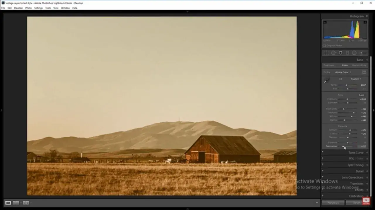 Paisaje rural con granero y montañas, con un filtro sepia aplicado en Photoshop para un estilo vintage.