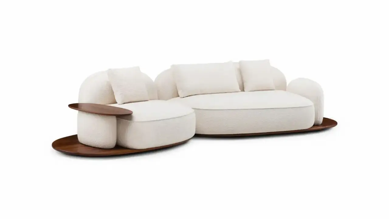 En mjuk, cremefärgad soffa med trädetaljer, designad av Luca Nichetto, står på en rund träplatta.