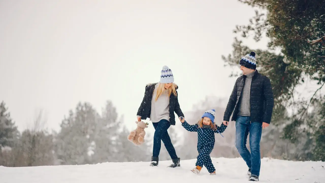 Famiglia felice in vacanze montagna bambini, camminano nella neve con cappelli coordinati.