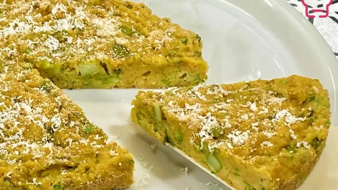 Una fetta di torta salata asparagi, dorata e cosparsa di parmigiano, pronta per essere gustata.