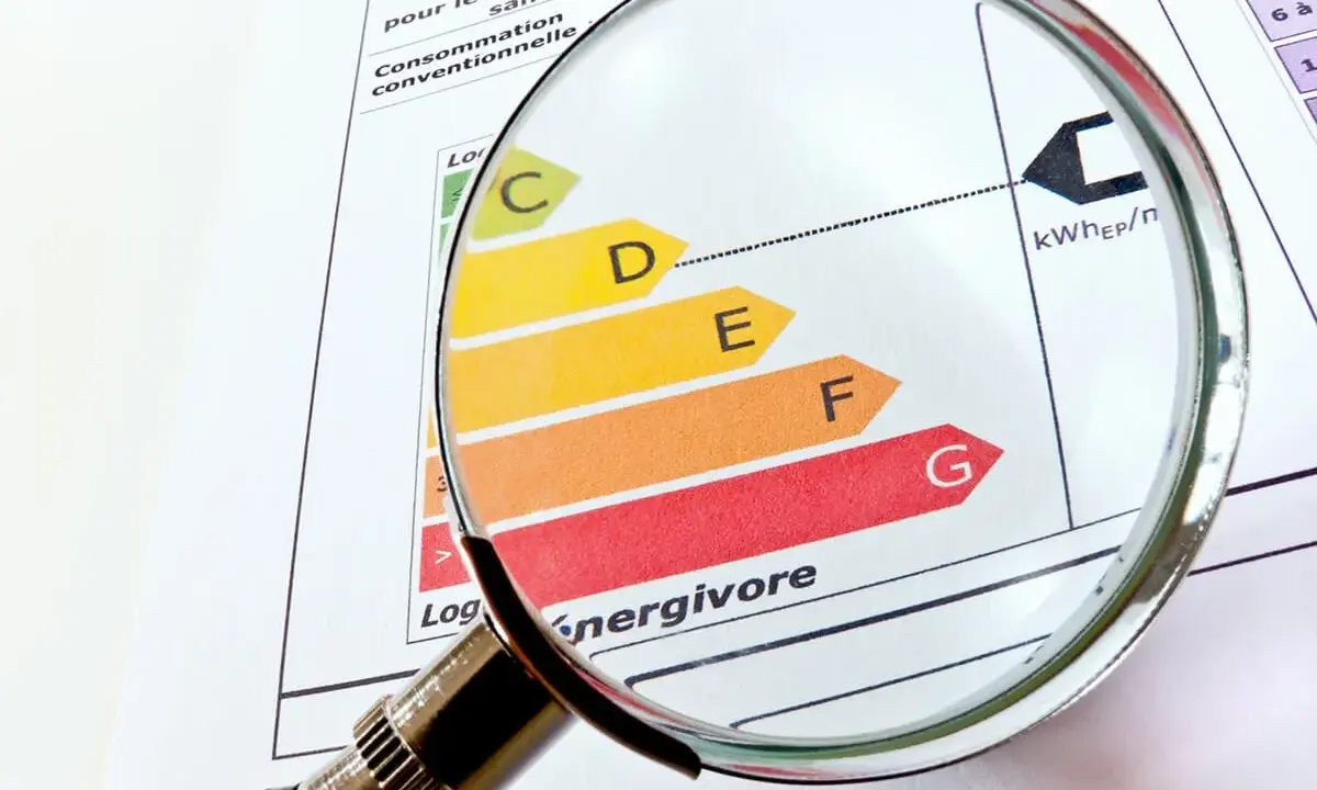 Loupe sur un classement énergétique, du vert au rouge, pour évaluer le DPE opposable d'un logement.