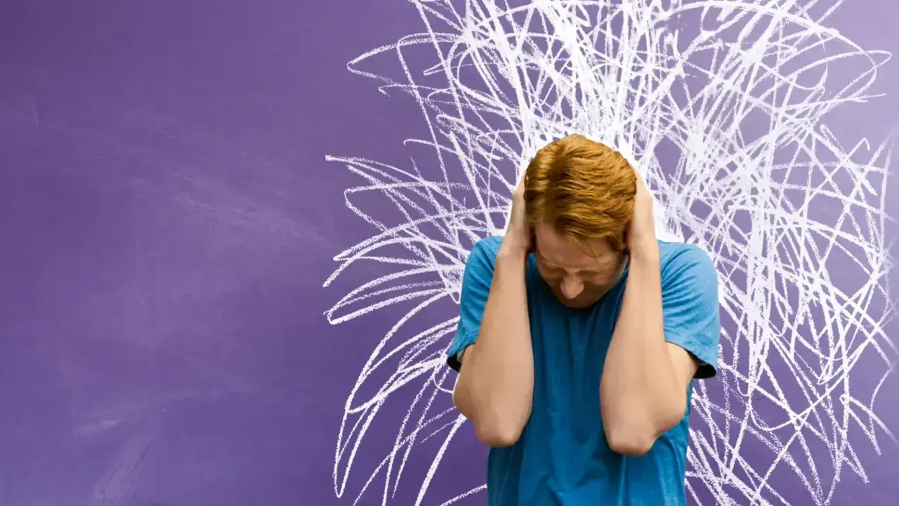 Junge mit roten Haaren hält sich die Ohren zu, vor chaotischer Kreidezeichnung. Ein Bild für die Herausforderungen von Kindern mit ADHS und Distanzlosigkeit.