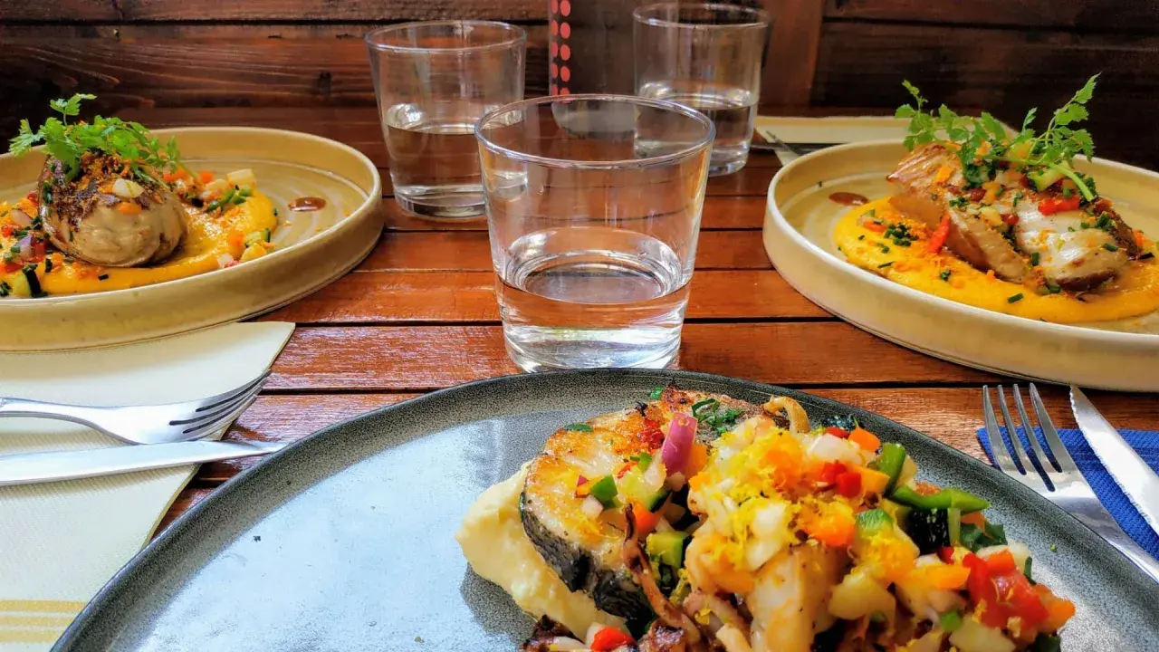 Trois assiettes de poisson grillé, purée de courge, légumes croquants et herbes fraîches. Une spécialité pyrénéenne à déguster.