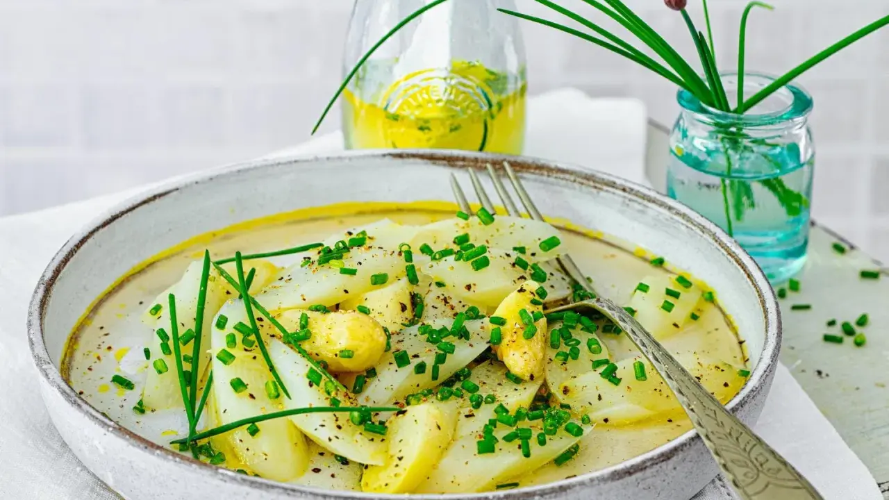 Ein Teller mit Spargel Salat, garniert mit Schnittlauch und einer leichten Sauce.