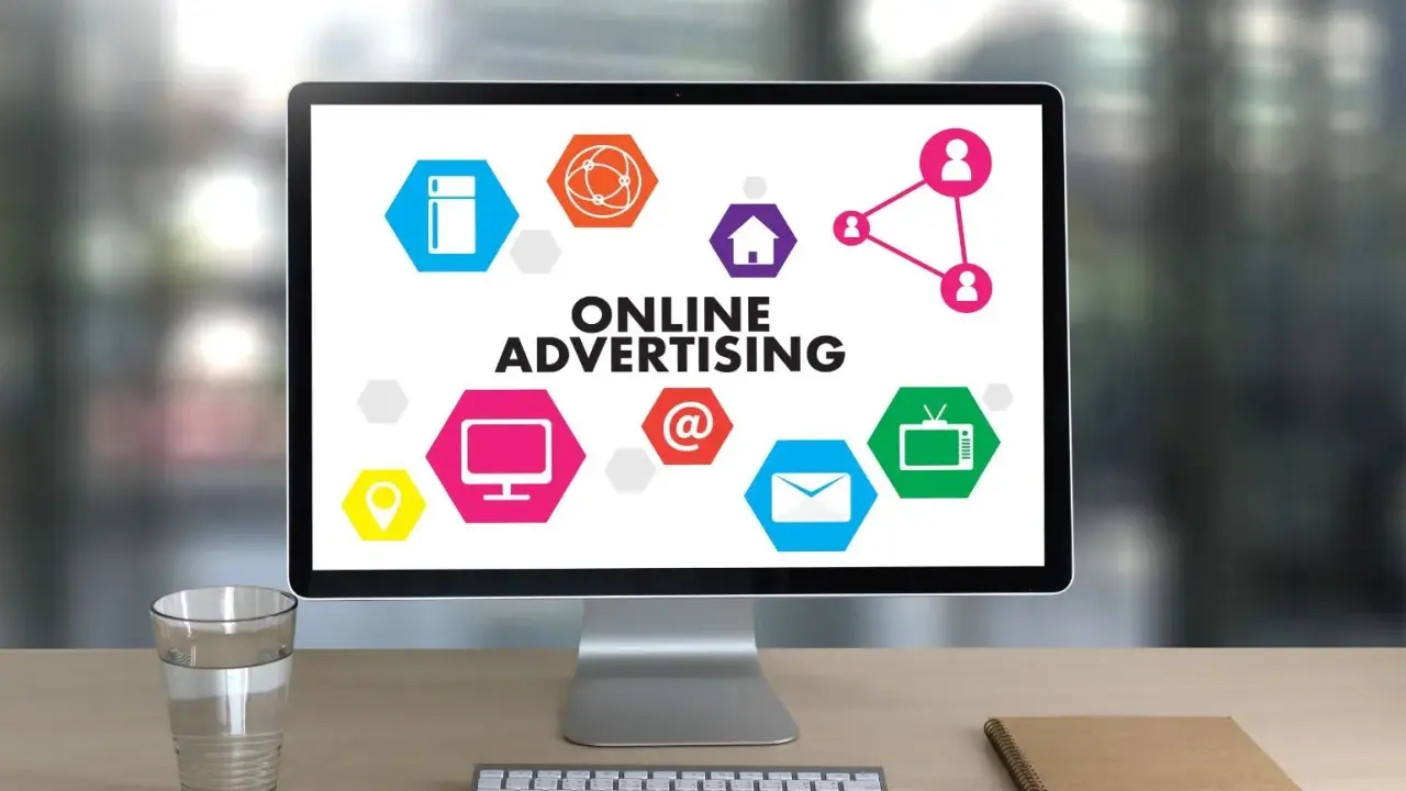 Komputer z hasłem "ONLINE ADVERTISING" i ikonami symbolizującymi różne formy reklamy online. Ciekawa reklama!