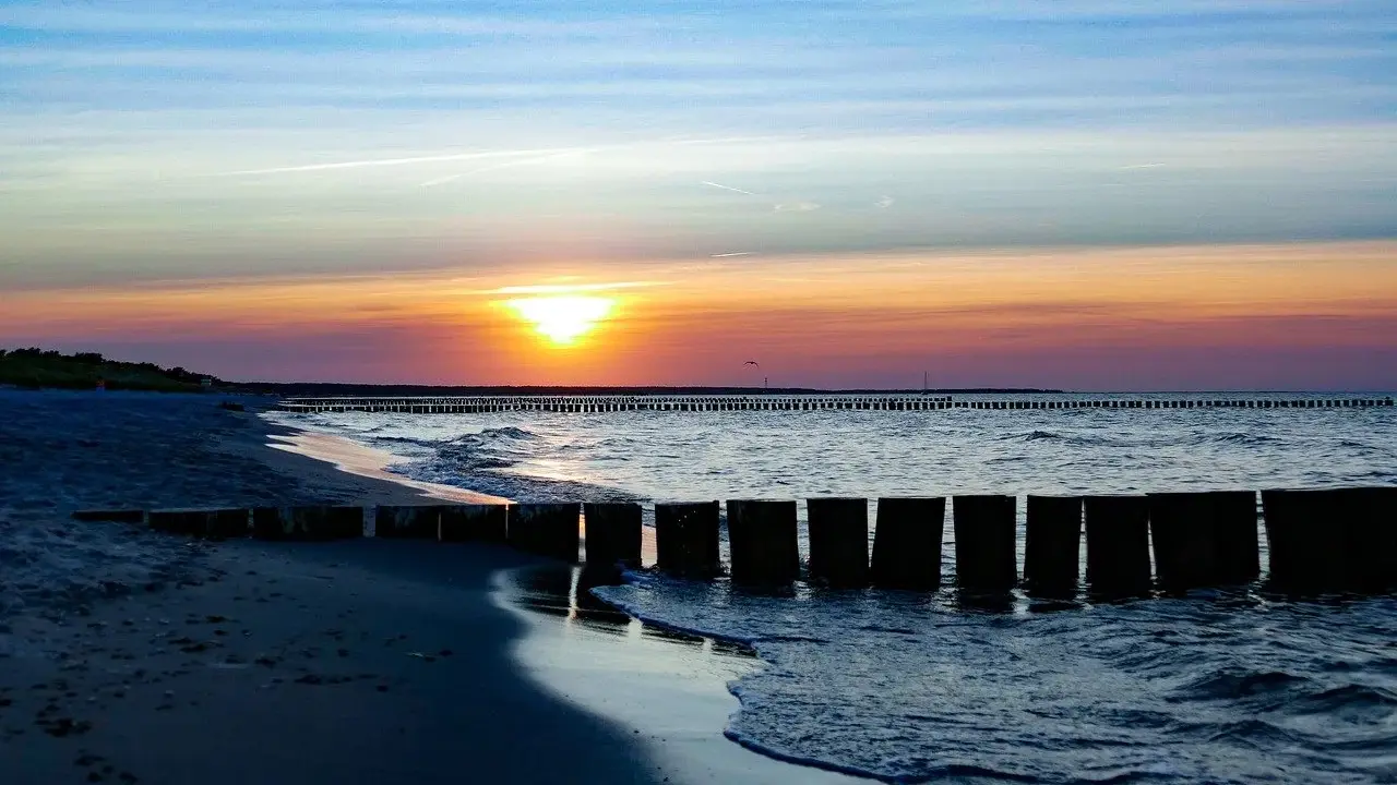 Zachód słońca nad Bałtykiem, falochrony i plaża w Sarbinowie. Piękne atrakcje Sarbinowo.