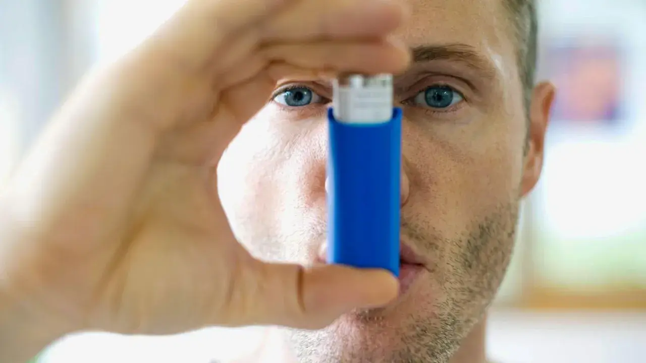Mann mit Inhalator, bereit gegen **Asthma und Hitze** vorzugehen.