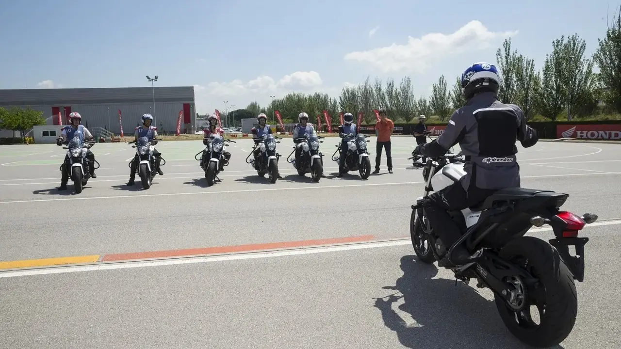 Grupo de motoristas en formación, listos para practicar con sus motos carmet a1 en un circuito.