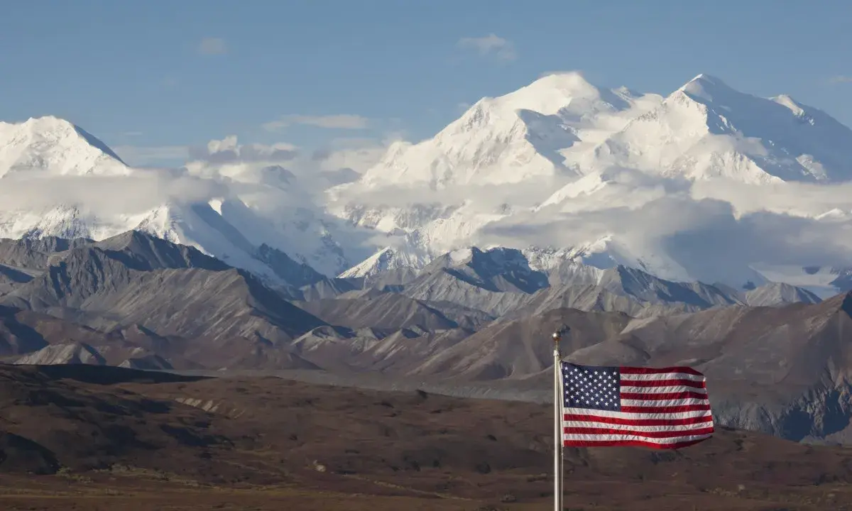 US-Flagge vor schneebedeckten Bergen des Denali Nationalparks.