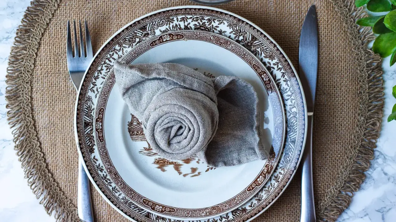 Enkel servettvikning i en vacker brunmönstrad tallrik, redo för en mysig middag.