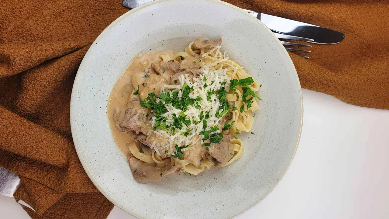 En krämig ryggbiff pasta med svamp, toppad med riven ost och persilja. En härlig middag!