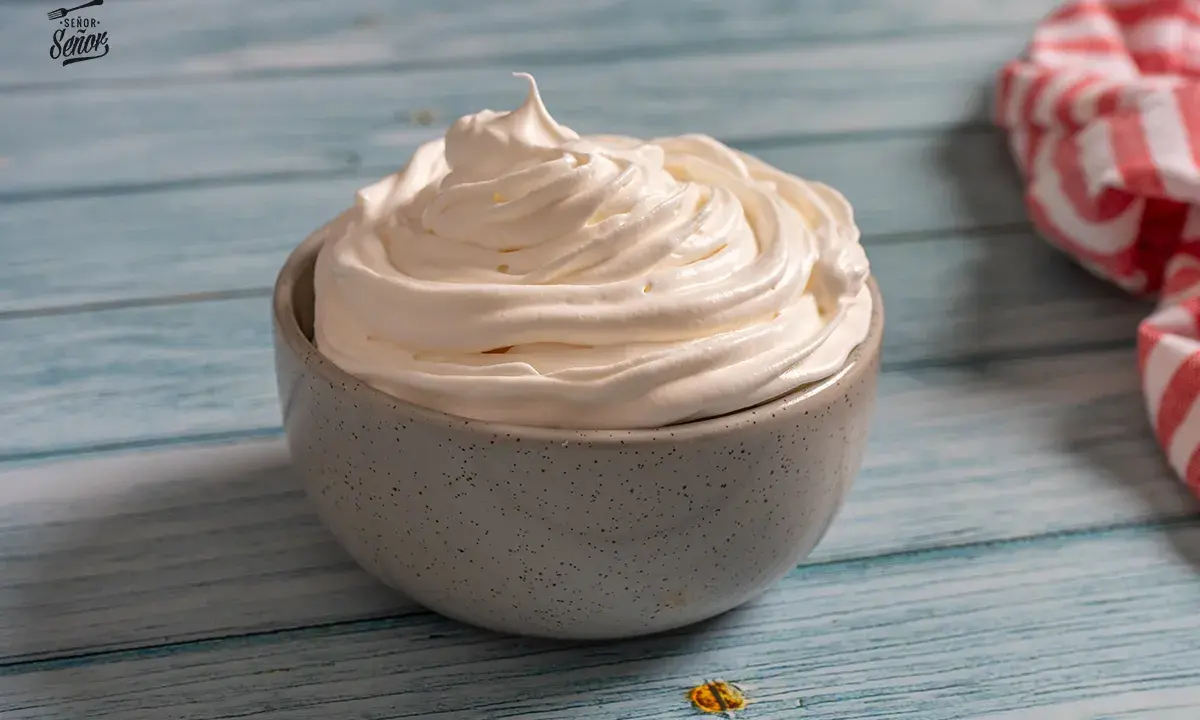 Nata montada perfecta en un cuenco gris, lista para decorar postres.