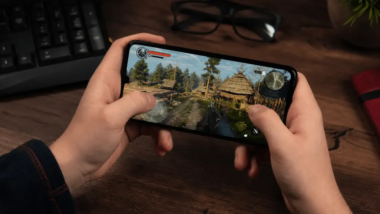 Ręce trzymają smartfon z grą akcji w stylu fantasy. To jedna z najlepszych gier mobilnych.
