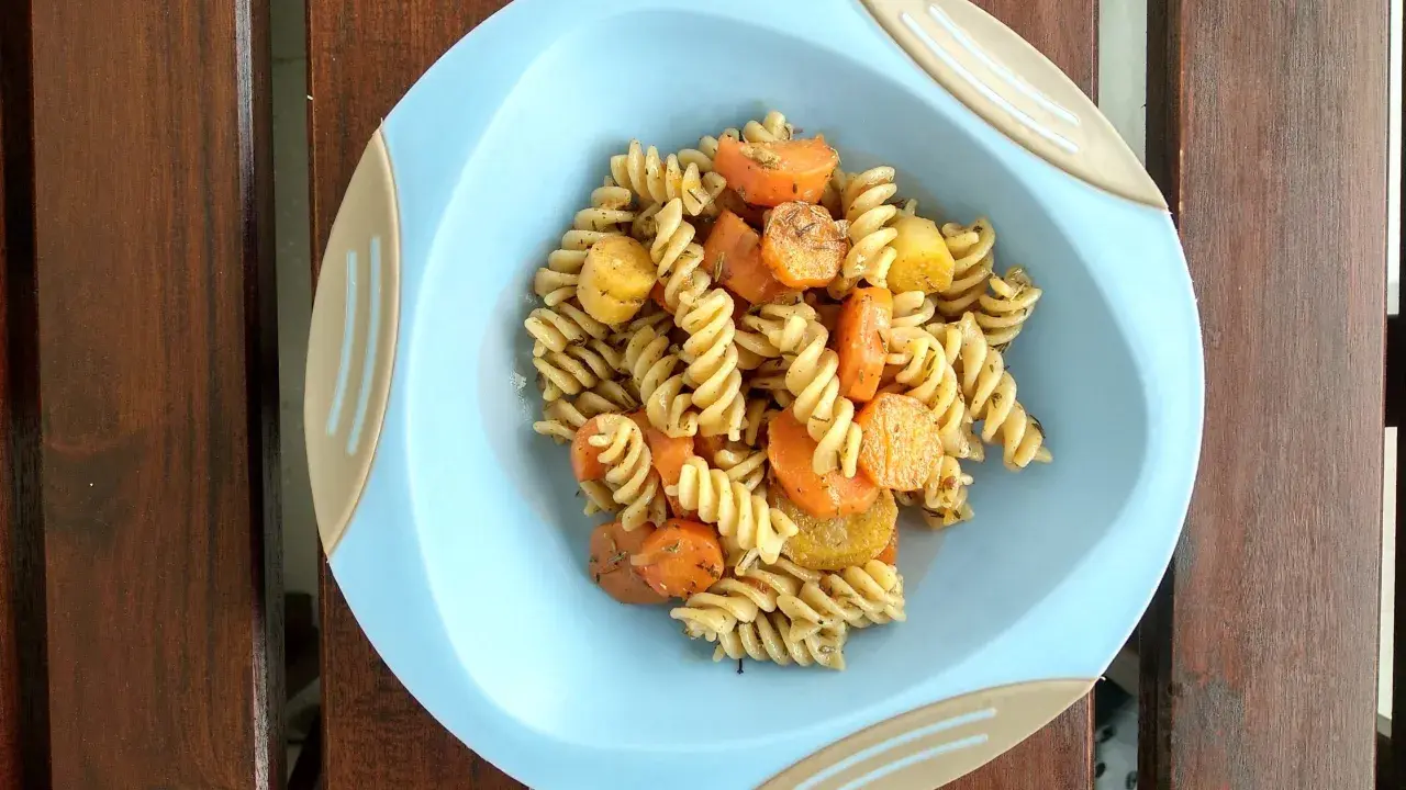 Szybki obiad dla niemowlaka: makaron fusilli z marchewką i ziemniakami, doprawiony ziołami.