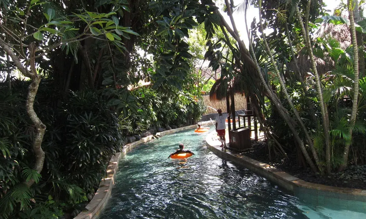Un día perfecto para viajar a Bali con niños, disfrutando de un río tranquilo rodeado de exuberante vegetación tropical.