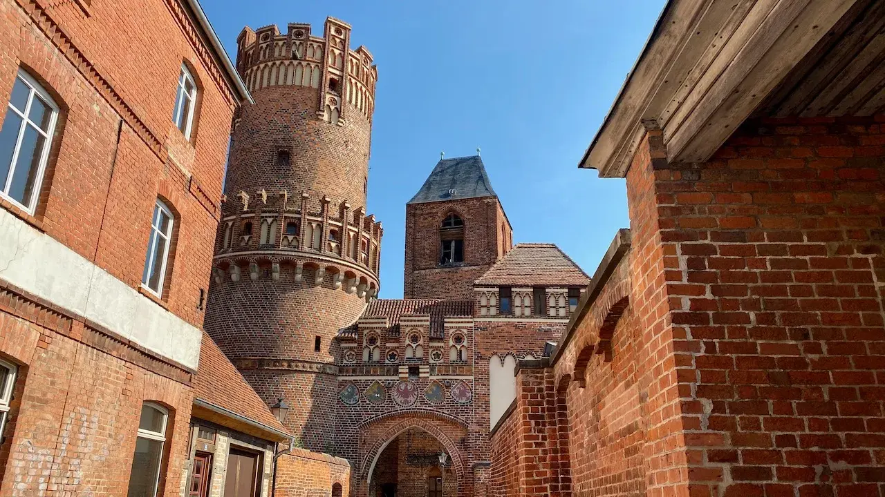Historische Backsteinarchitektur mit einem runden Turm und Torbogen. Ein tolles Motiv für Ausflugsziele Sachsen-Anhalt.