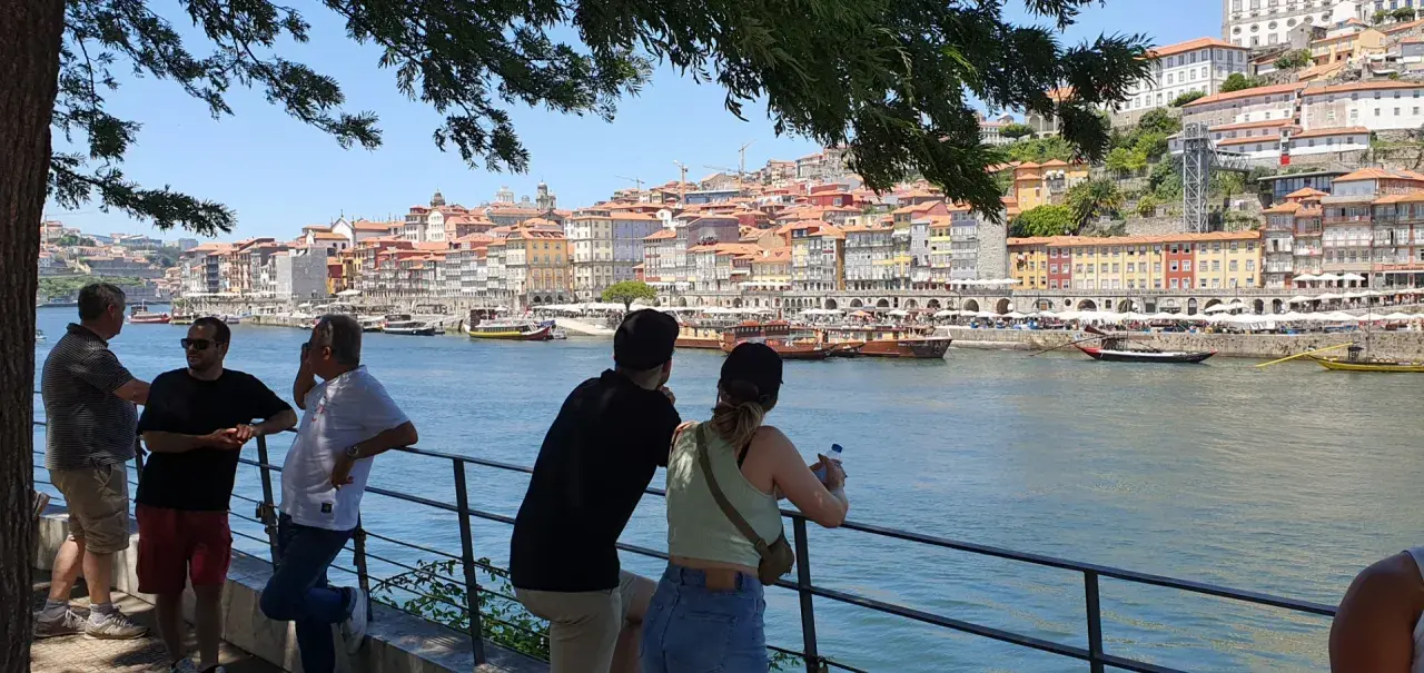 Blick auf Porto mit bunten Häusern und dem Fluss. Eine Gruppe genießt die Aussicht, eine tolle Porto Card Erfahrung.