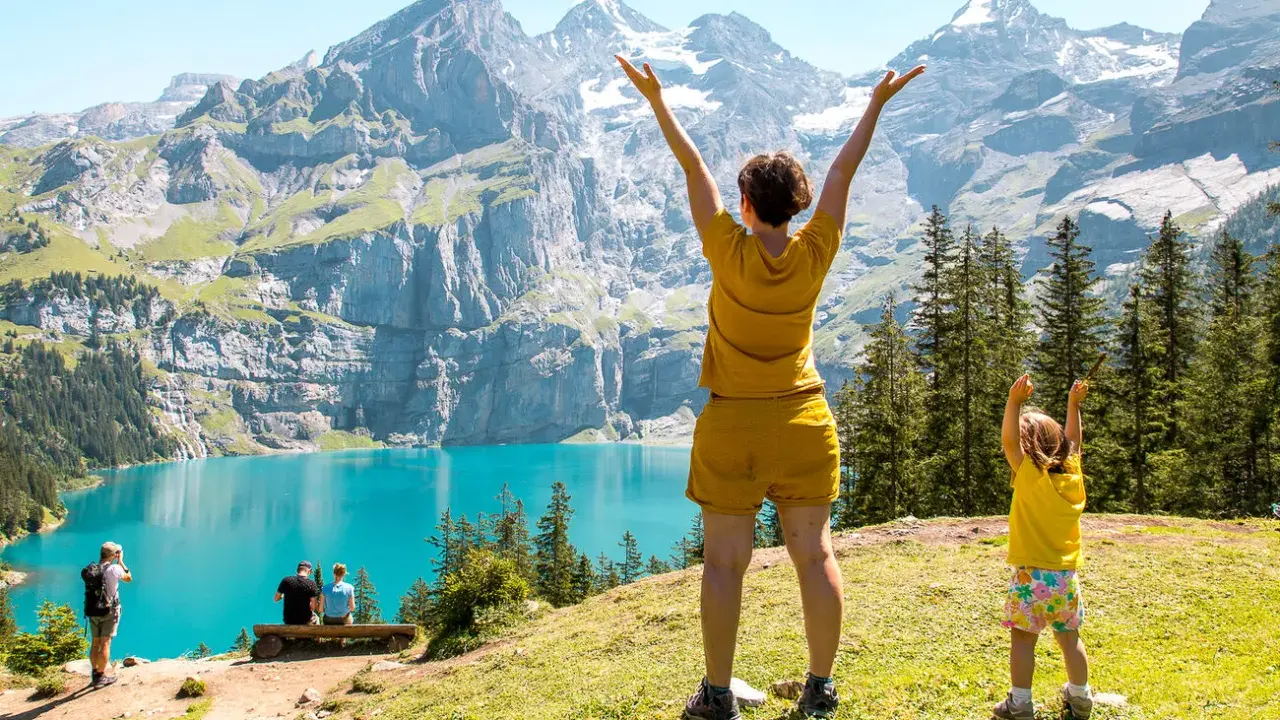 Familia disfrutando de un día en la suiza con niños, con un lago turquesa y montañas imponentes de fondo.