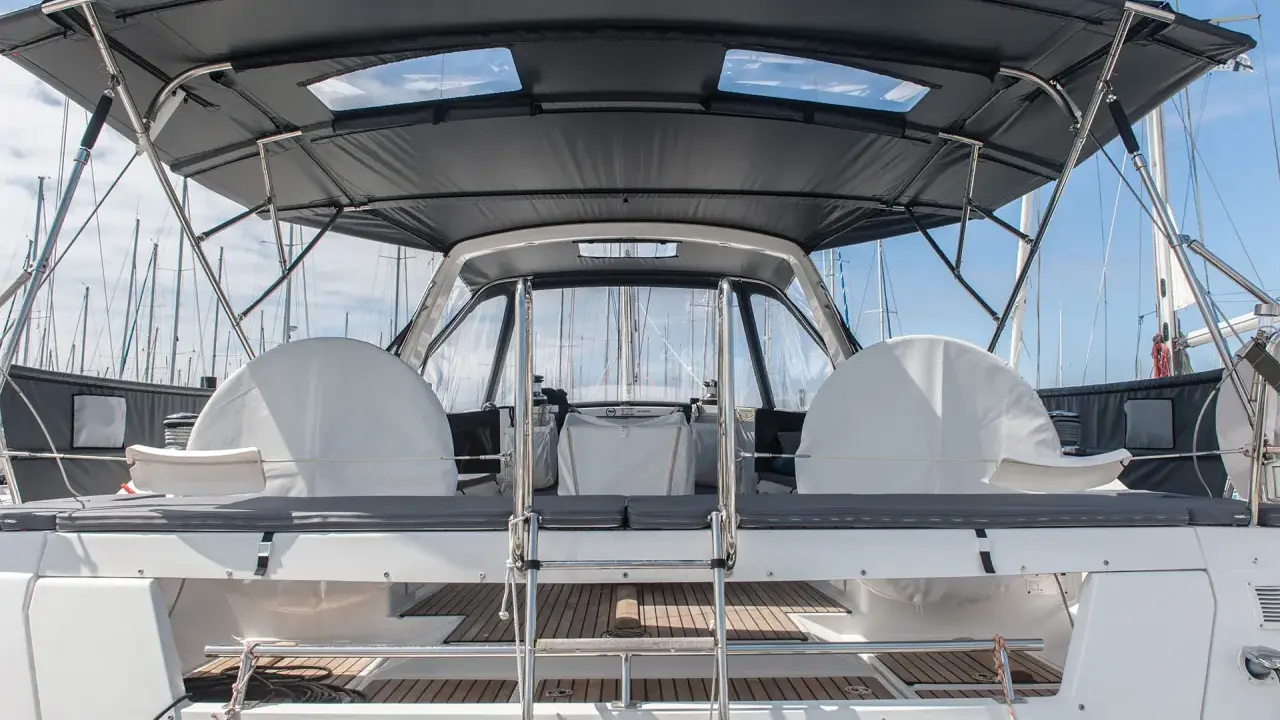 Le taud de bateau, prêt à être refait, protège les deux barres à roue sous un ciel bleu.