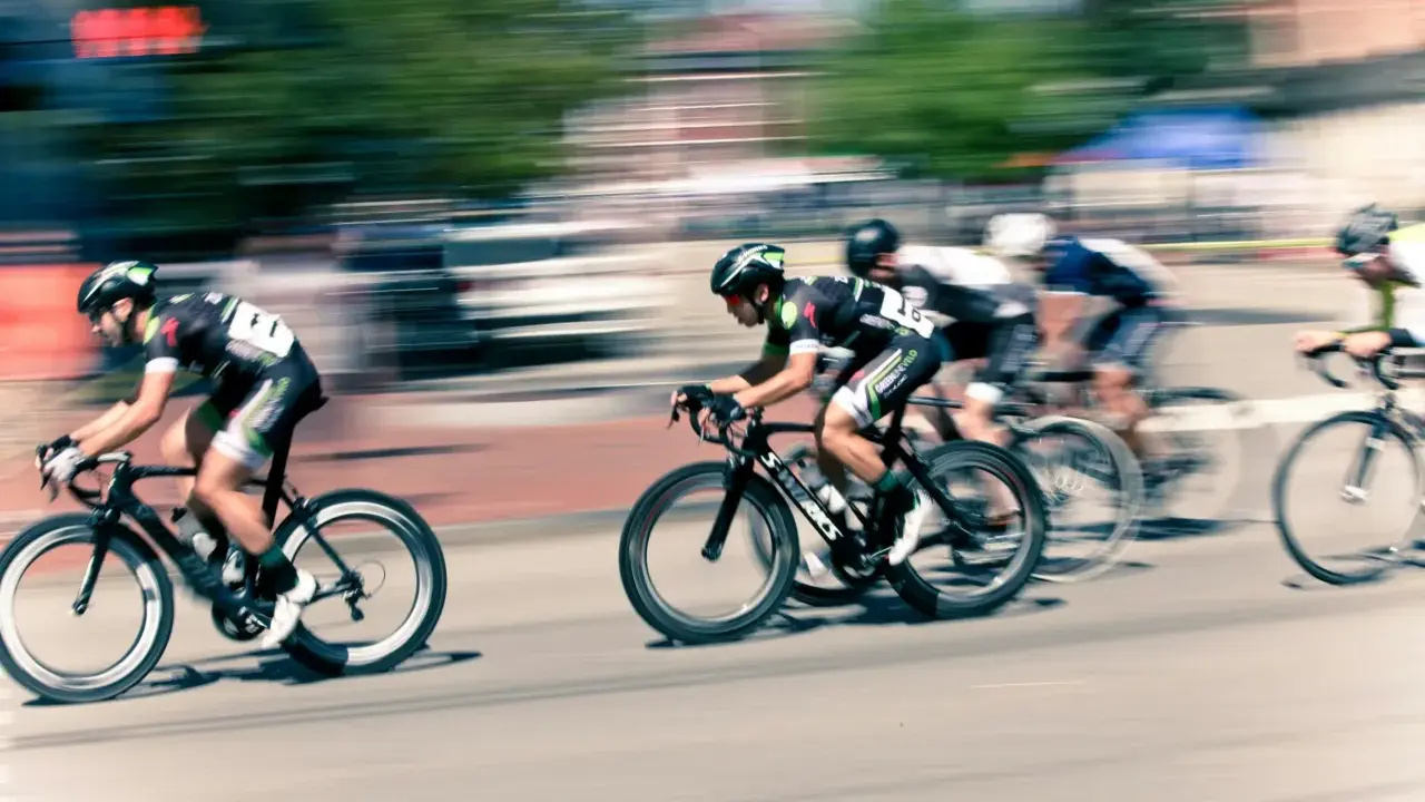 Ciclistas en carrera, capturados con un barrido fotográfico que resalta la velocidad y el movimiento.