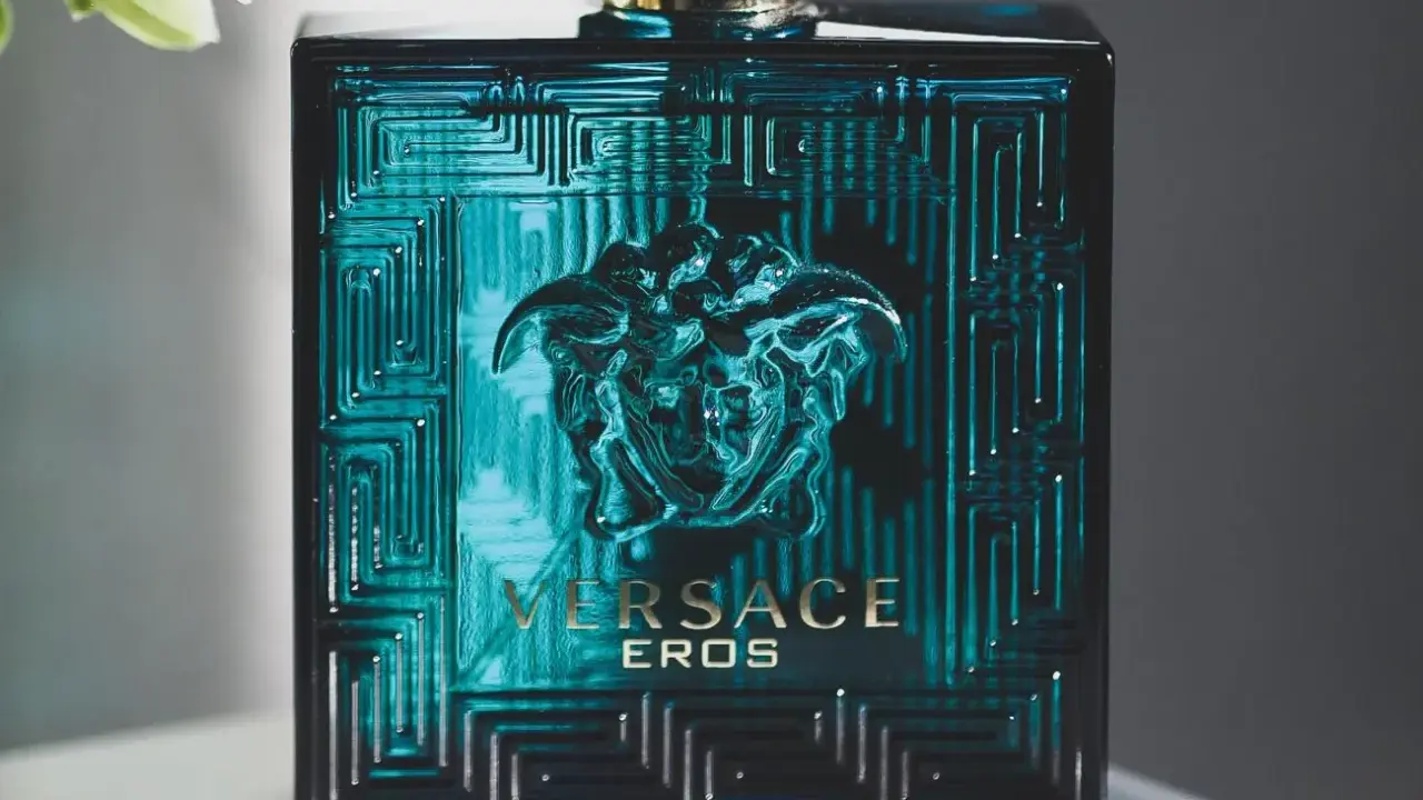 Butelka perfum męskich Versace Eros w turkusowym kolorze z greckim wzorem i głową Meduzy.