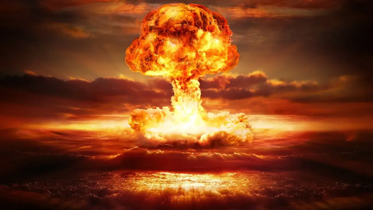 Potężny grzyb atomowy nad oceanem. Widoczne przerażające skutki bomby jądrowej: fala uderzeniowa, ogień i dym.