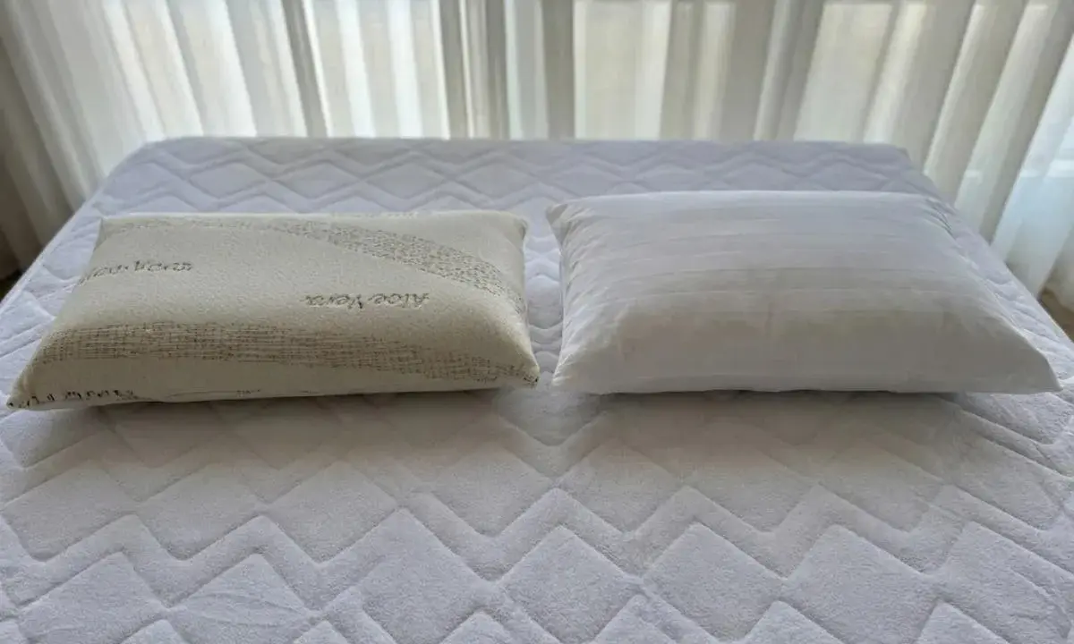 Dos almohadas sobre un colchón: una de fibra con Aloe Vera y otra viscoelástica. ¿Qué es mejor almohada de fibra o viscoelástica?