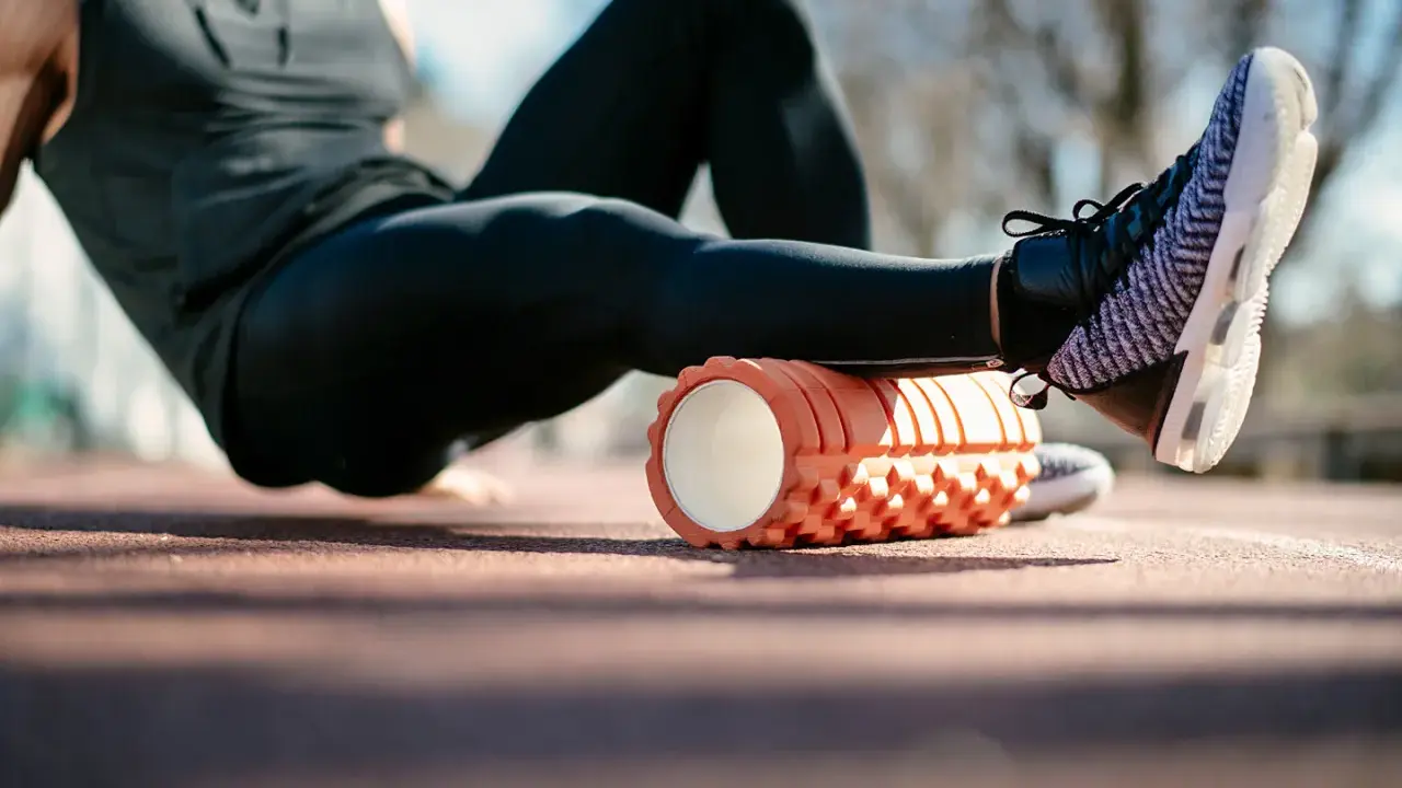 Sportler nutzt eine Faszienrolle vor oder nach dem Training zur Regeneration der Beinmuskulatur.