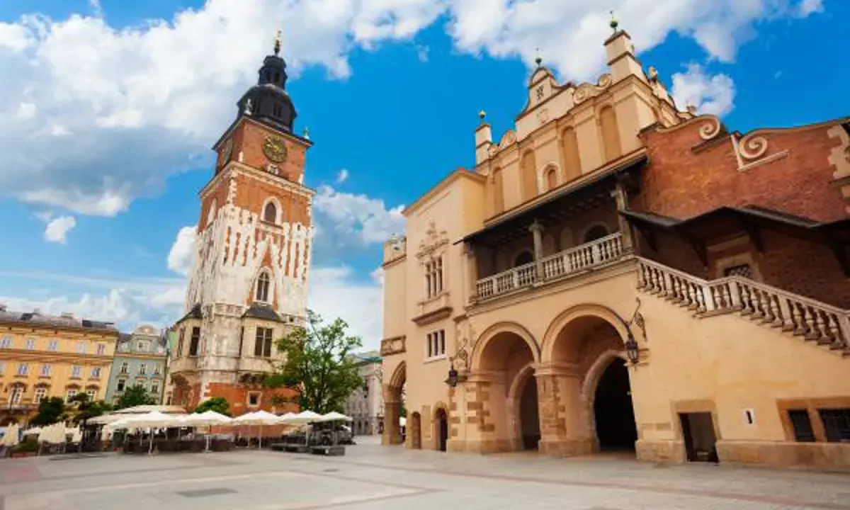 Wieża ratuszowa Kraków na Rynku Głównym, obok Sukiennic. Słoneczny dzień, błękitne niebo z chmurami.