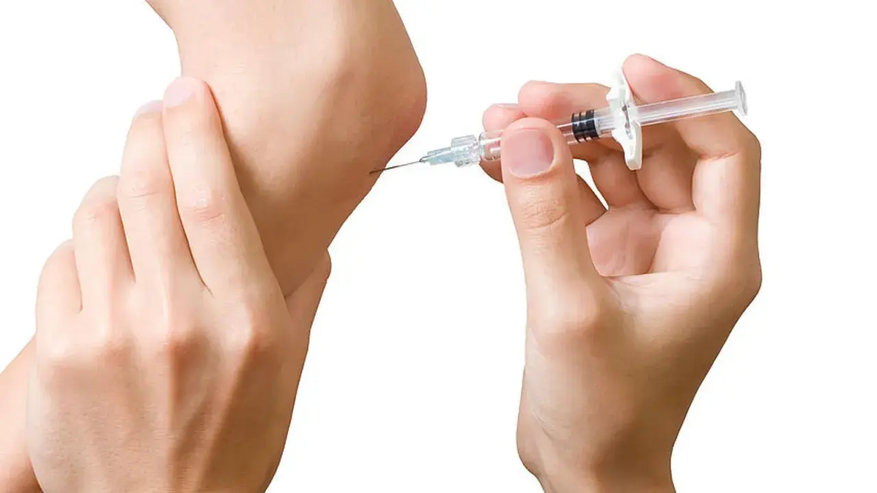 Eine Spritze wird an einem Ellbogen angesetzt. Dies ist ein Schritt in der biologika therapie zur Behandlung von Entzündungen.