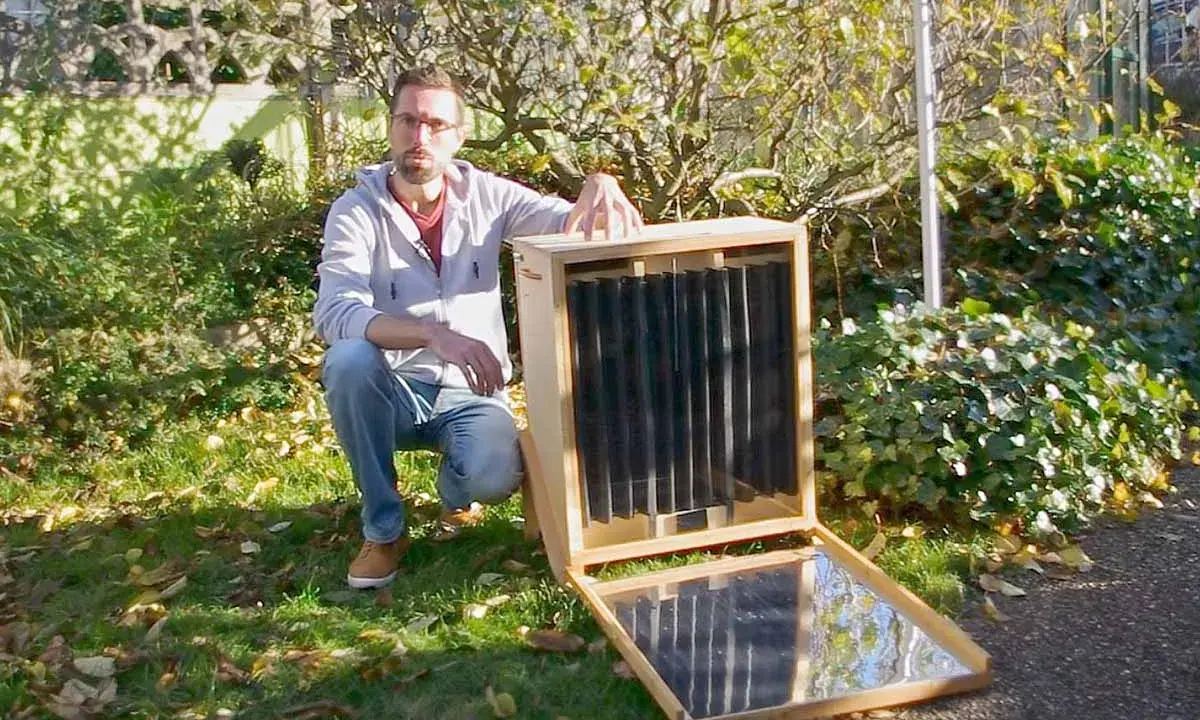 Un homme présente un séchoir solaire plan, un appareil ingénieux pour sécher des aliments grâce à l'énergie du soleil.