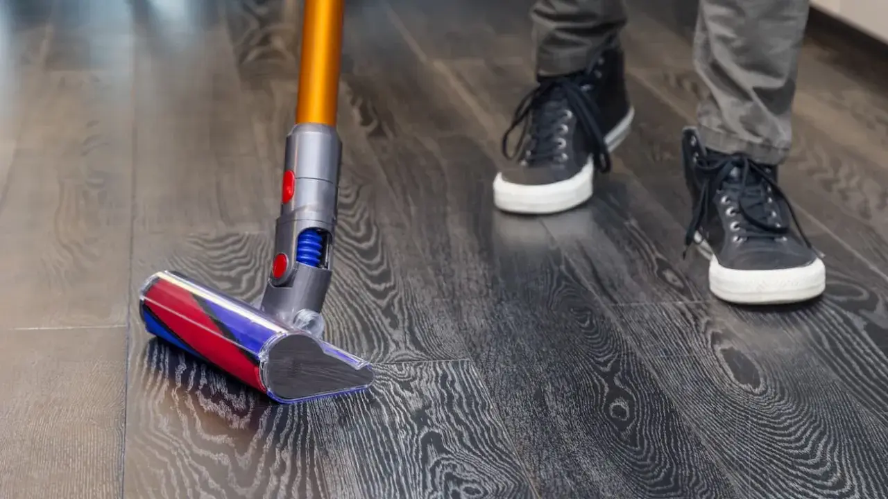 Aspiradora moderna limpia suelo vinílico con acabado de madera. Paso a paso, como limpiar suelo vinilico para un hogar impecable.