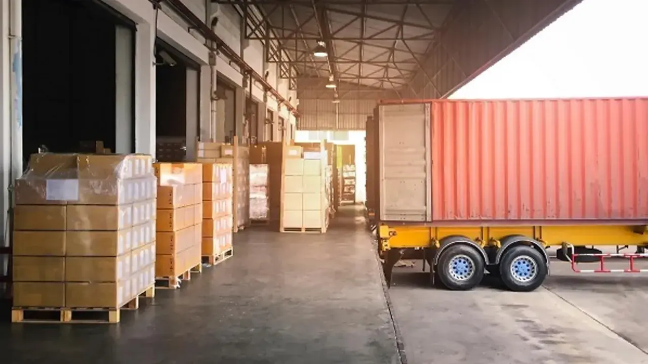 Almacén con camión y contenedores listos para la normativa de carga y descarga de camiones.