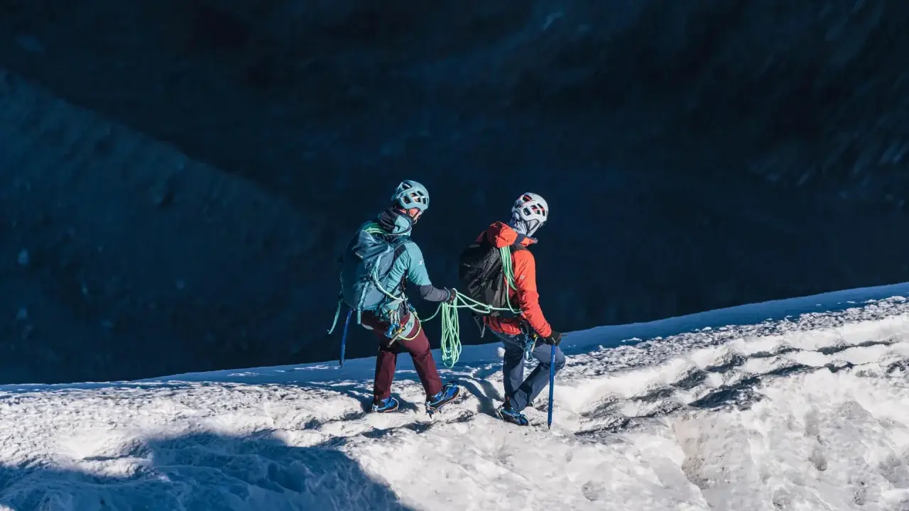 Dwóch alpinistów z raki i czekanami na lodowcu, przygotowuje się do wspinaczki.