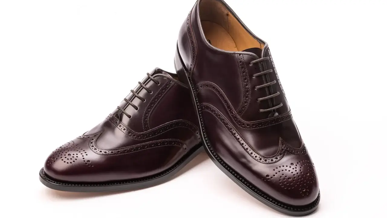 Elegante, dunkelbraune Herrenschuhe im **full brogue** Stil mit Lochmuster und Schnürung.