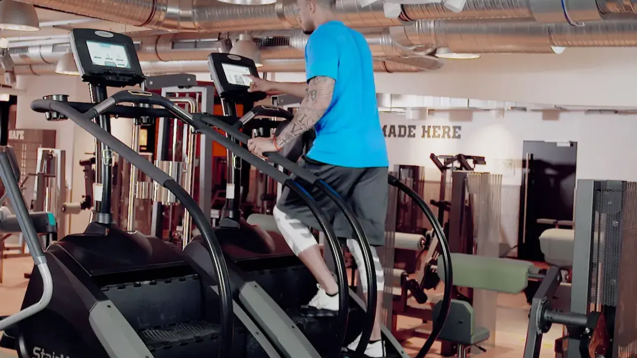 Mann trainiert auf einem Stairmaster im Fitnessstudio.