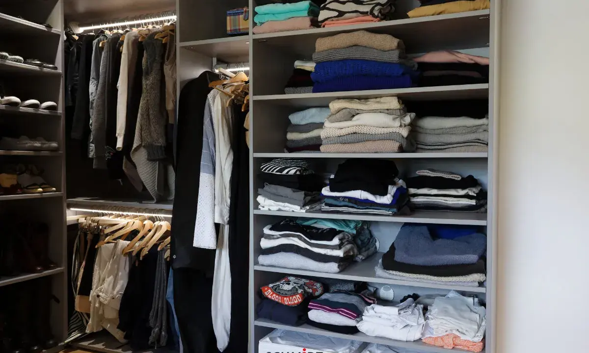 Un dressing bien organisé : vêtements pliés et suspendus, chaussures rangées. Idéal pour savoir comment organiser son dressing.