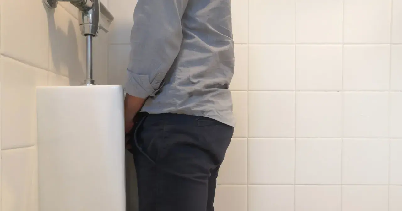 Mężczyzna przy pisuarze. Szukasz domowych sposobów na pieczenie przy oddawaniu moczu?
