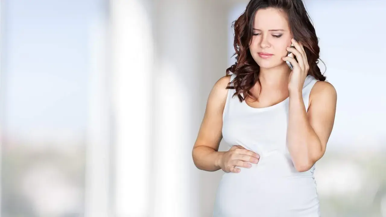 Gravid kvinna med orolig min ringer om sina Braxton Hicks sammandragningar.