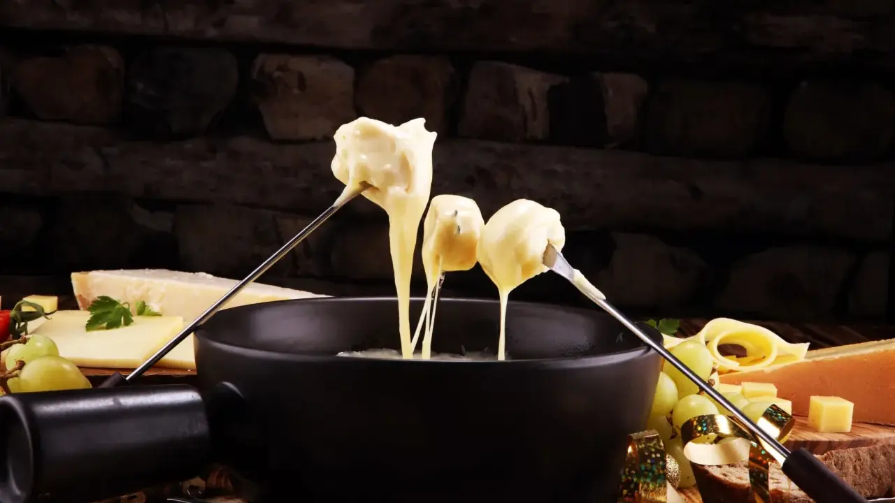 Fondue au fromage, une des spécialités culinaires parisiennes, servie avec du pain et des raisins.