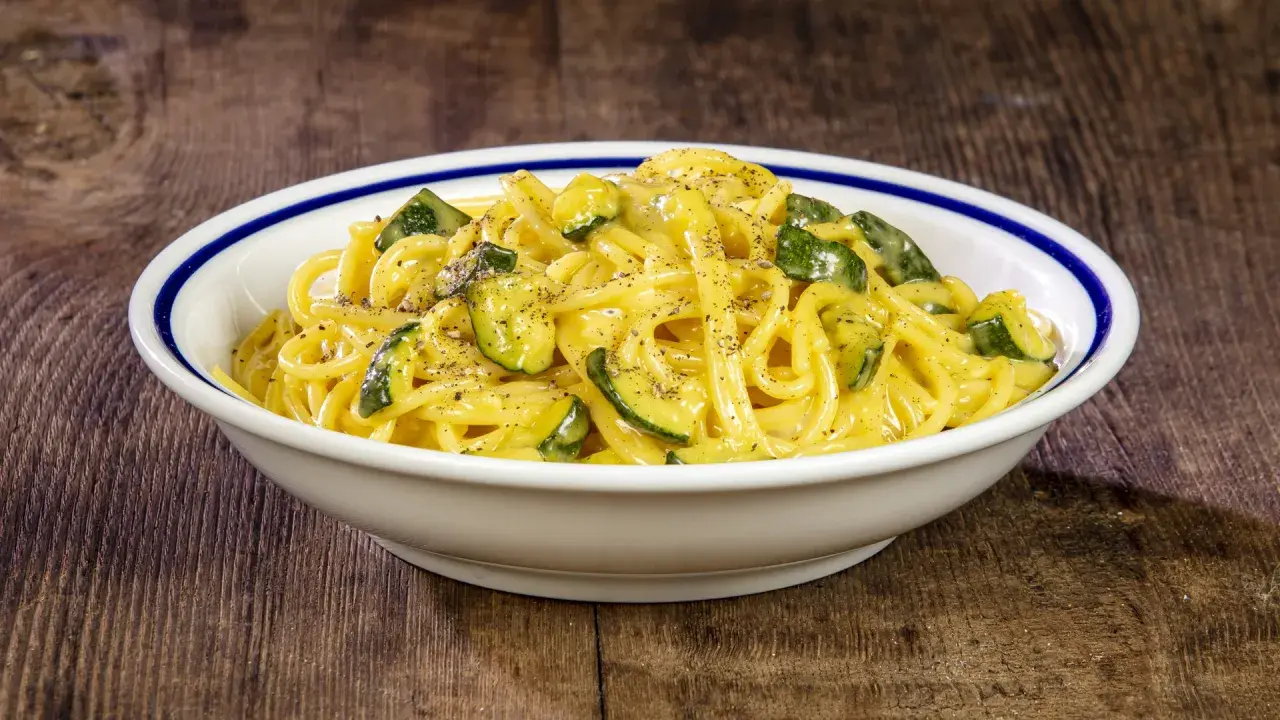 Spaghetti cremosi con zucchine, un'interpretazione fresca della carbonara di zucchine, guarniti con pepe nero macinato.