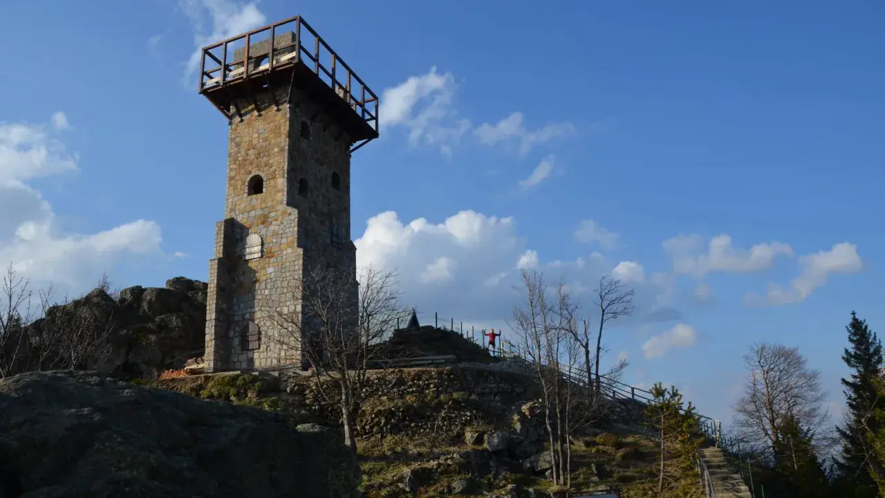 Wysoki kamień, wieża widokowa na szczycie góry, z drewnianym tarasem i schodami prowadzącymi do niej.