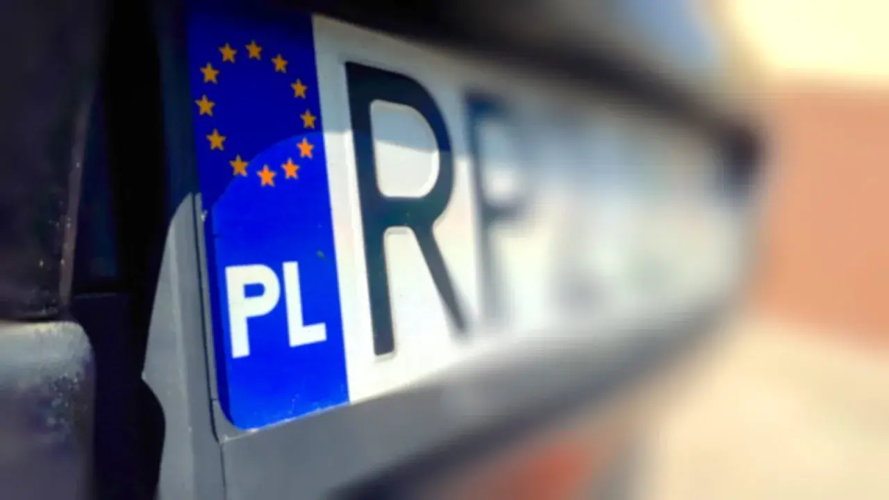 Zbliżenie na polską tablicę rejestracyjną z symbolem UE. Czy przy przerejestrowaniu samochodu trzeba oddać tablice?