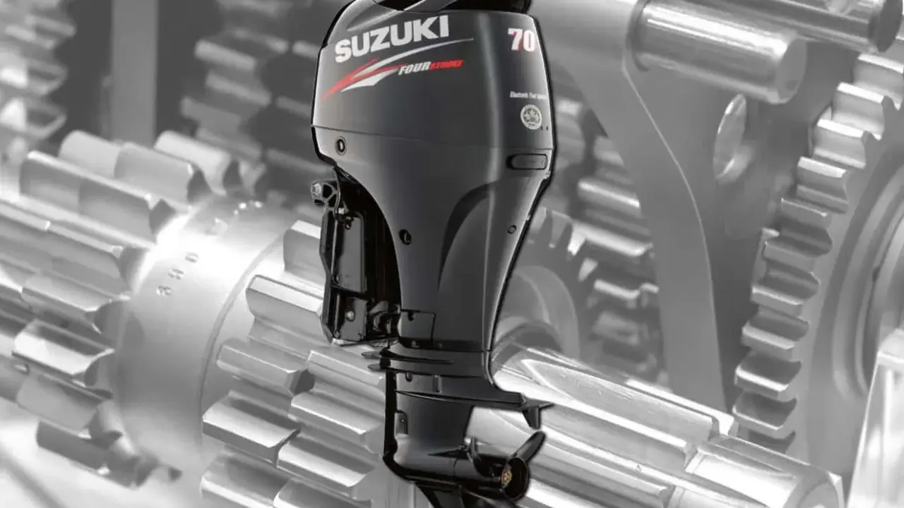 Moteur hors-bord Suzuki DF 70, vu sur fond de rouages mécaniques. Une image pour la revue technique.