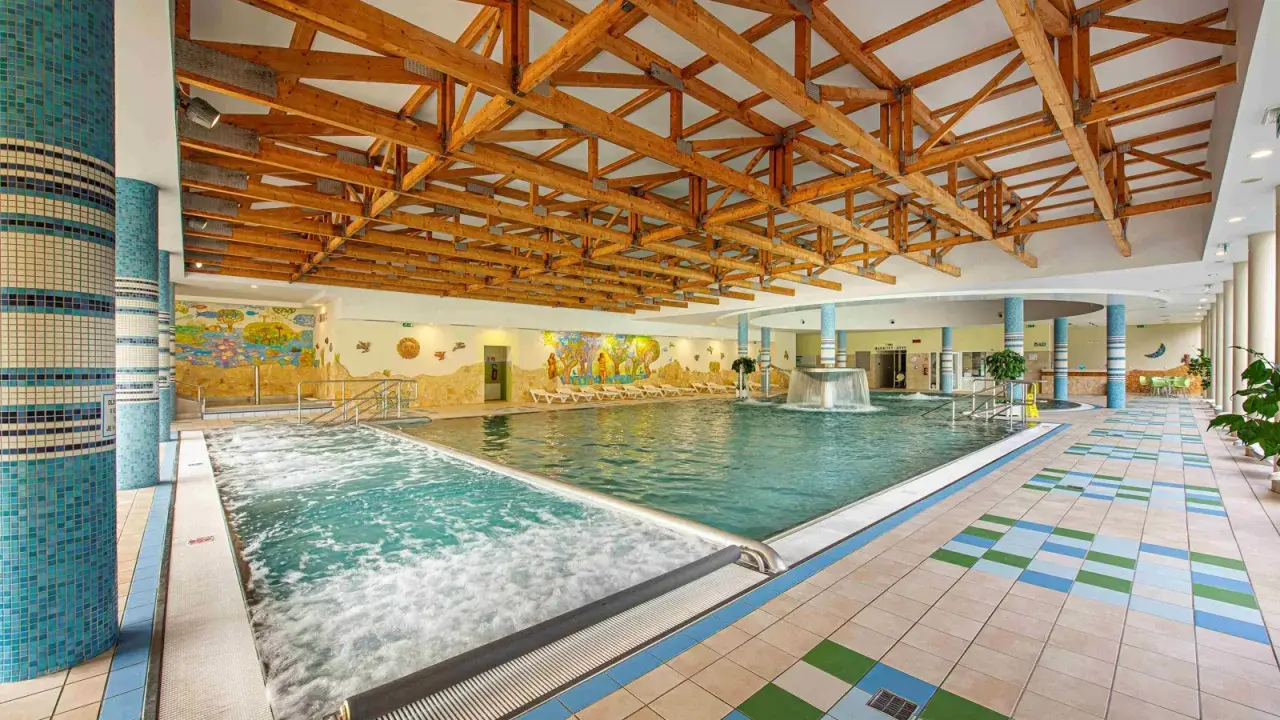 Wnętrze basenu z jacuzzi i kaskadą. Sprawdź bardejowskie termy cennik i zaplanuj relaks.