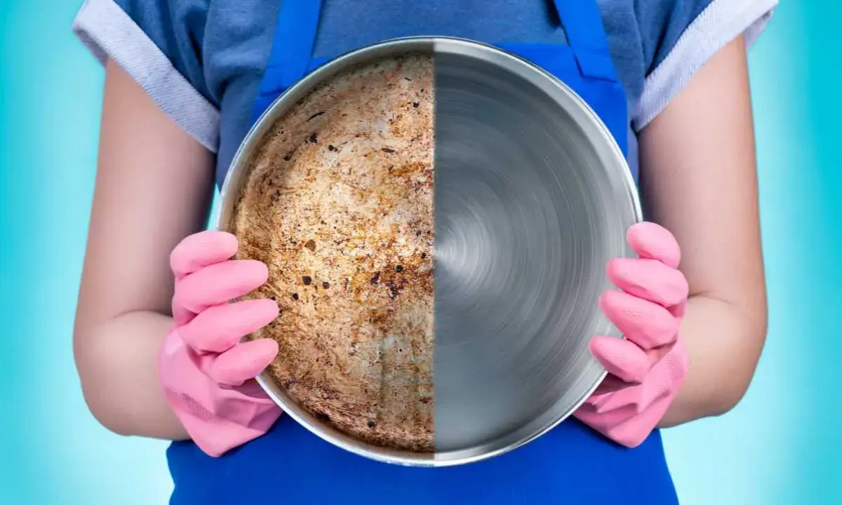 Una padella in acciaio divisa a metà: da un lato incrostata e sporca, dall'altro lucida e pulita.