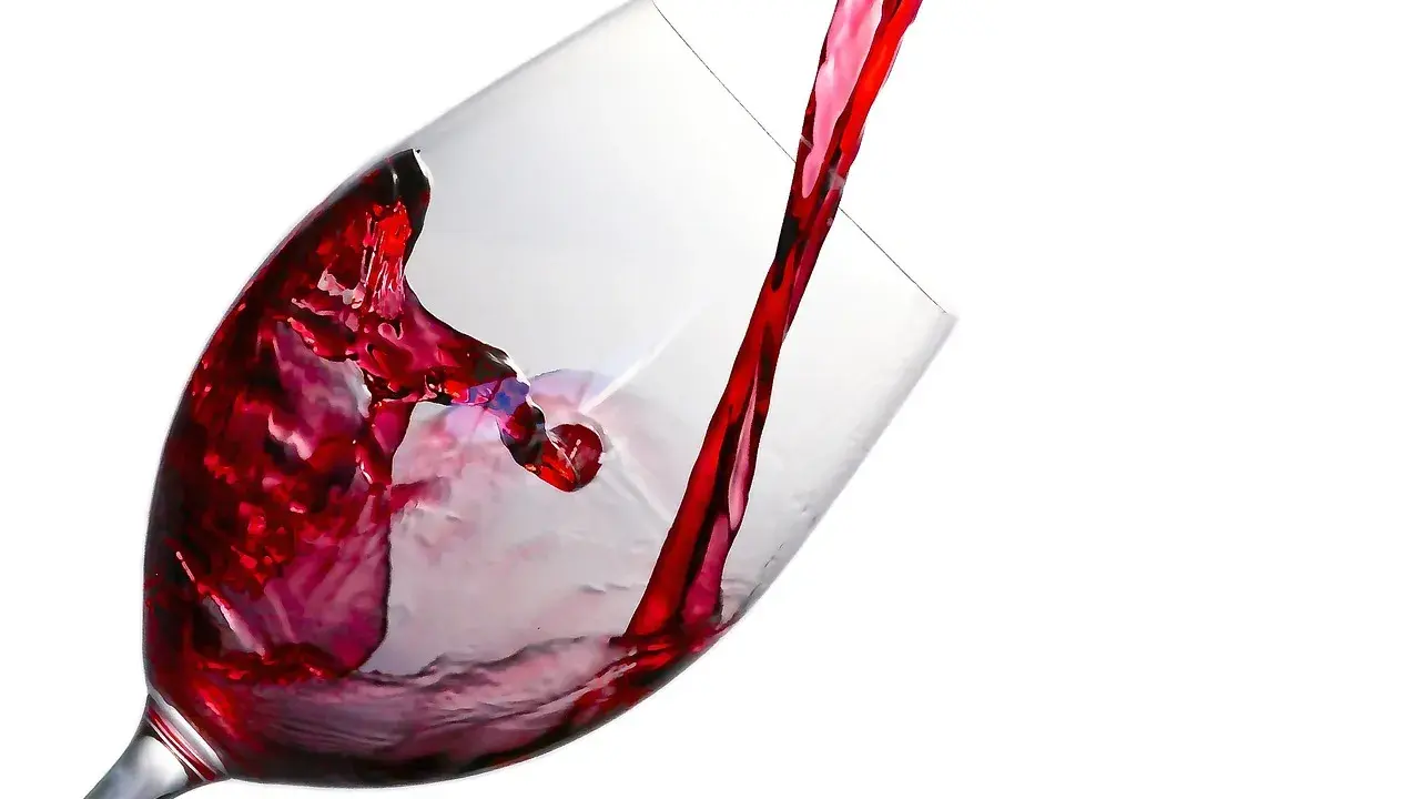 Czerwone wino leje się do kieliszka, tworząc wiry. Ile promili w lampce?